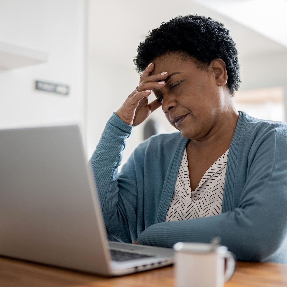 Woman at computer with a headache