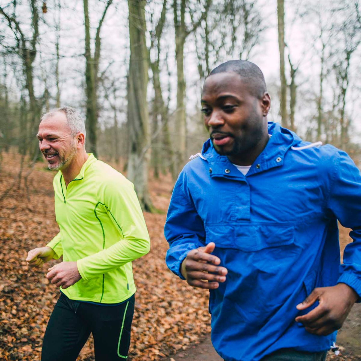 Two friends jogging up the trails in the forest to get fit.