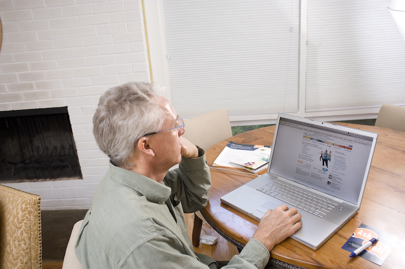 A man reviews a web site on the his laptop computer.