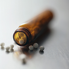 Open pill bottle, pills spilling out.
