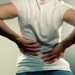 Woman holds her lower back in pain