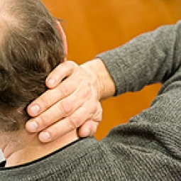 Man holding neck in pain.