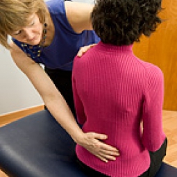 A woman performing spinal manipulation.