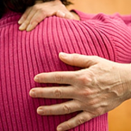 A woman holds her neck in pain