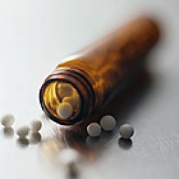Open pill bottle, pills spilling out.