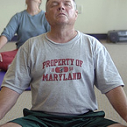Participants in a yoga class meditating while in the lotus pose.