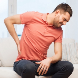 A man holds his back in pain