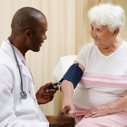 A close up of a stethoscope taking a pulse on an arm in a pressure cuff