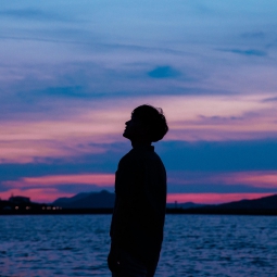 man looking into sky over ocean