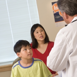 A mother and son talk to a doctor.