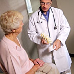 Doctor showing bone model to elderly woman