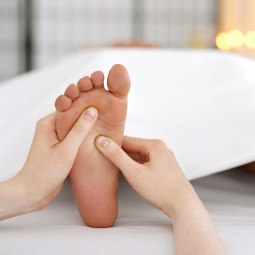 reflexologist massaging a woman's foot