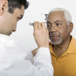 man having eyes checked by opthamologist