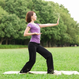 Woman doing tai chi on grass 