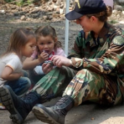 LT Elizabeth Leavitt, a health services officer, takes a break to enjoy a moment with local El Salvadoran kids.