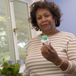 Woman examining a pill bottle.