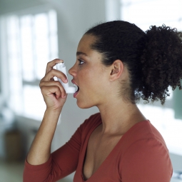 A young woman about to use an inhaler.