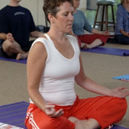 A woman Meditating during a yoga class.