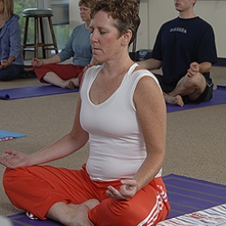 A woman practices a meditative yoga pose.