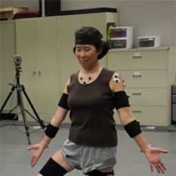 A woman practices yoga while wearing electronic position monitors.