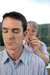 Acupuncturist inserts needles into a man's ear.