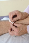Acupuncturist inserting needle into a patient's arm using sterile technique.