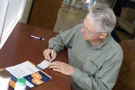 A man fills out a Time to Talk patient wallet card.