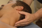 Massage therapist manipulating the head and neck during a massage session.