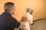 Massage therapist providing seated massage.