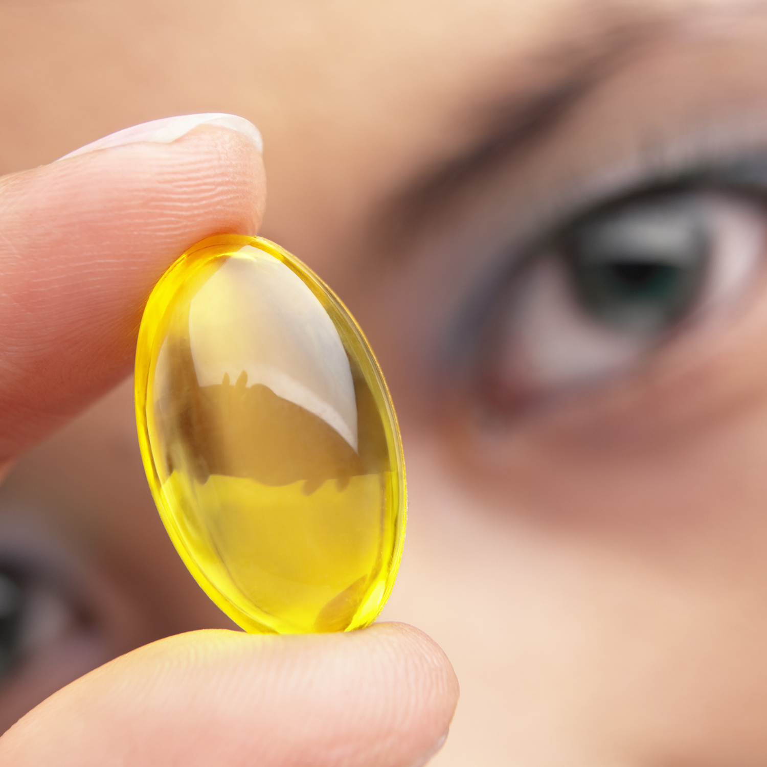 woman holding a capsule in front of her face